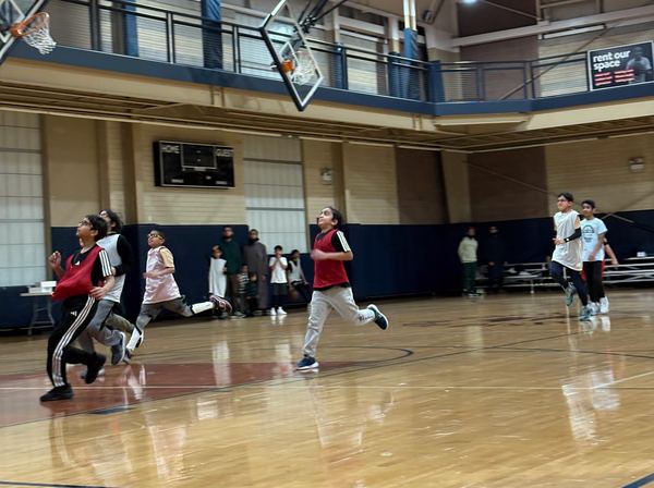 Kids sprinting down the court toward the basket.